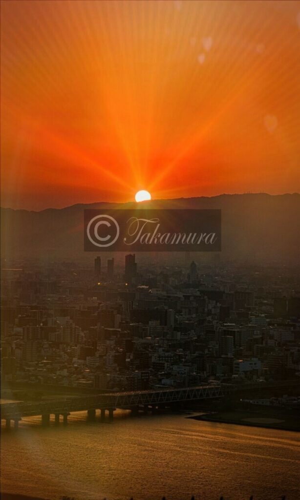 梅田スカイビル展望台から真っ赤に染まり光り輝く特徴ある太陽の写真や風景